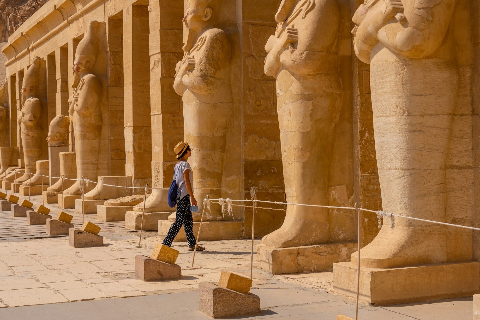 A young woman with pharaoh sculptures entering Hatshepsut's Funerary Temple in Luxor. Egypt