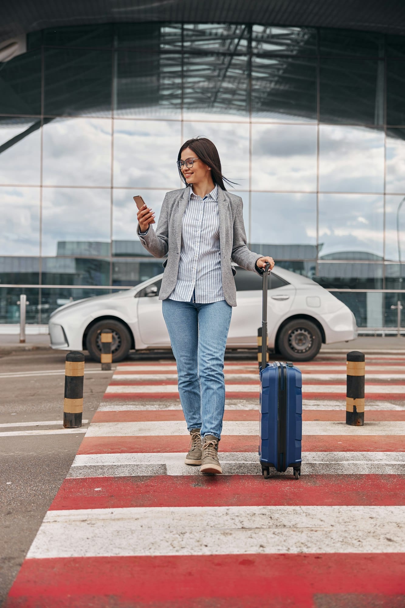 Happy caucasian woman traveller in airport terminal with luggage